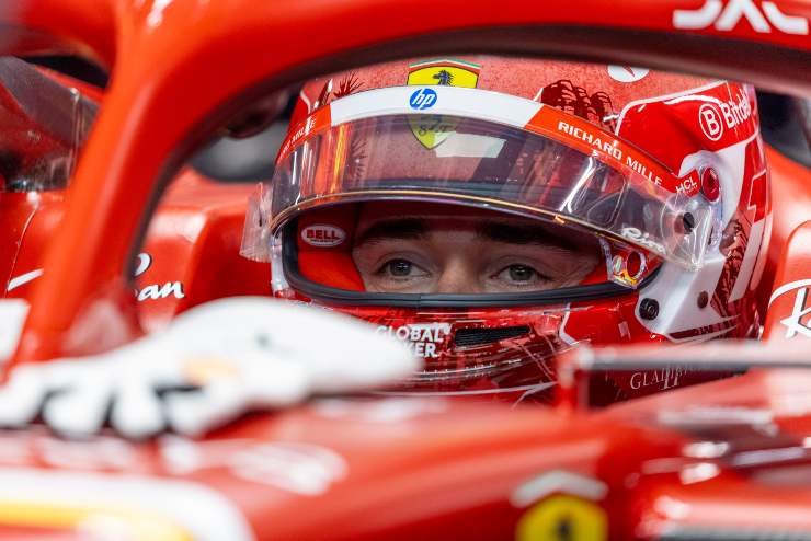 Primo piano di Leclerc con la visiera alzata nella sua Ferrari